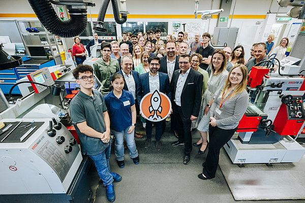 Gruppenfoto mit Mitarbeitern und Führungskräften in einer Werkstatt Gruppenbild in einer Werkstatt