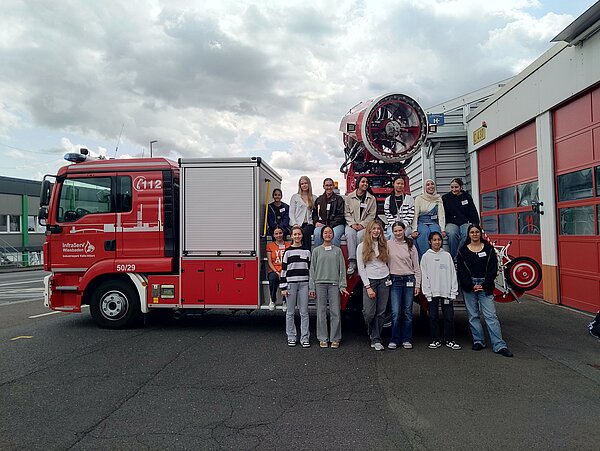 Gruppe von Menschen steht vor einem Feuerwehrauto Gruppe vor einem Feuerwehrauto